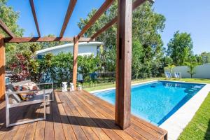 a wooden deck with a swimming pool in a yard at The Wave in Horseshoe Bay