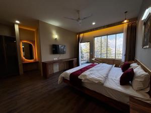 a bedroom with a large bed and a large window at Cedar wave in Munsyari
