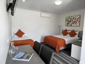 a hotel room with two beds and a table with a table at Paruna Motel in Swan Hill