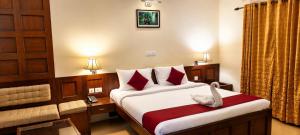 a bedroom with a bed with a white bird sitting on it at Hotel Xavier's Avenue in Kadavoor +5 photos