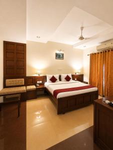 a bedroom with a large bed and a couch at Hotel Xavier's Avenue in Kadavoor