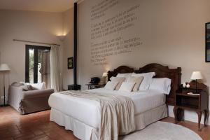 a bedroom with a large white bed and a chair at Encís d'Empordà -Adults Only- in Casavells