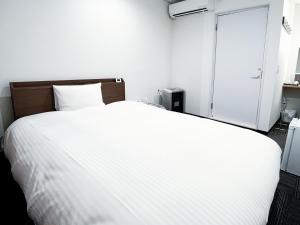 a white bed in a white room with a door at CHALET BURLAP FURANUI in Furano +116 photos