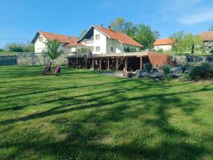 a yard with two chairs and a house at Imanje Mihailovic 2 in Pružatovac