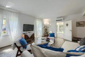 a living room with a couch and a tv at Holiday House Altea in Banjole