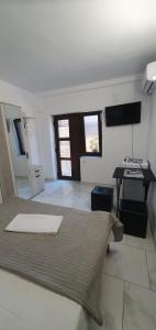 a room with a bed and a desk and a television at Casa Ghemus Costinesti in Costinesti