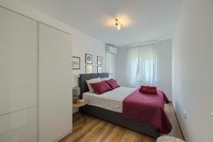 a bedroom with a bed with a red blanket at Holiday House Altea in Banjole