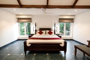 a bedroom with a large bed and two windows at Le Mont Lagoon Home Stay in Cochin