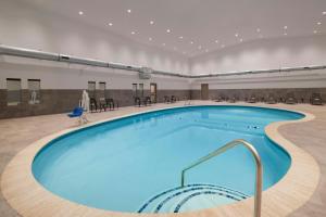 a large pool in a large room with tables and chairs at Four Points by Sheraton Rock Springs in Rock Springs