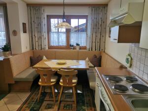 a small kitchen with a table and chairs and a stove at Balthasarhof, Haus in Finkenberg