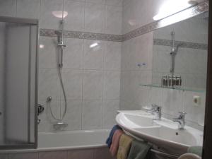 a bathroom with a sink and a shower and a tub at Balthasarhof, Haus in Finkenberg +51 photos