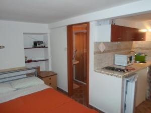 a room with a bed and a kitchen with a microwave at Apartment IVANKA -KROK in Baška