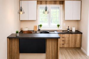 a kitchen with white cabinets and a black counter top at Galaxy Apartments in Belgrade