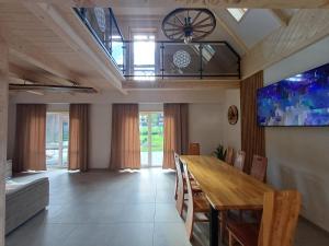 a dining room with a wooden table and chairs at Domek u Szwajnosów in Ciche
