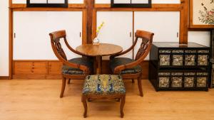 a wooden table and two chairs with a table and a table and chairsuggest at HAEMIL Hanok 해밀한옥 in Seoul