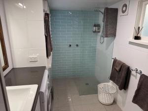 a bathroom with a shower and a toilet and a sink at Boatsheds in Sawtell +19 photos