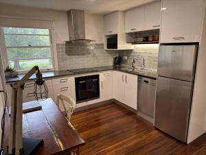 a kitchen with white cabinets and stainless steel appliances at Boatsheds in Sawtell