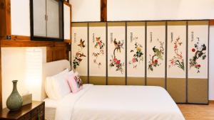a bedroom with a bed with flowers on the wall at HAEMIL Hanok 해밀한옥 in Seoul