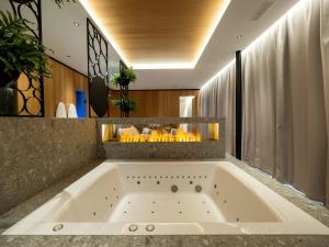 a bath tub in a bathroom with a fireplace at Hotel von Rotz in Wil +61 photos