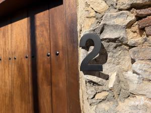 a metal number on the side of a stone wall at Melograno Lofou in Lofou