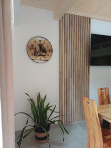 a dining room with a plant and a clock on the wall at Domek u Szwajnosów in Ciche