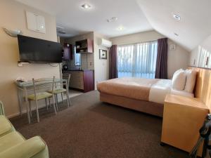 a hotel room with a bed and a kitchen at Athena Motel in Christchurch