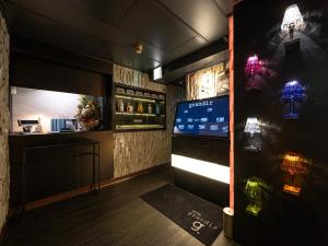 a room with a bar with a tv and lights at grandir ｸﾞﾗﾝﾃﾞｨｰﾙ -Adult Only- in Yokohama