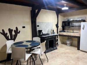 a kitchen with a table and chairs and a fireplace at Rincón del río B&B in Ángeles