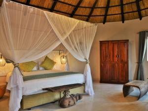 a bedroom with a bed with a canopy at Masumu River Lodge in Binga +60 photos