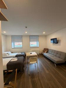 a large room with two beds and a couch at M70 Apartmanház in Miskolc