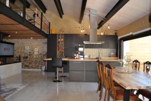 a large kitchen with a wooden table and chairs at El Loft de Can Padrosa in Riumors