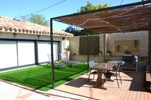 a patio with a table and a green lawn at El Loft de Can Padrosa in Riumors