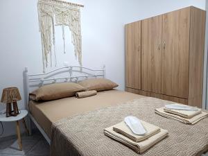 a bedroom with a bed with towels and a cabinet at Eva's House in Amarynthos
