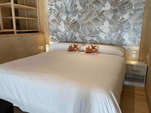 two kittens sitting on top of a white bed at Can Padrosa Mini loft 3 in Riumors +37 photos