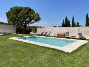 a swimming pool in a yard with chairs and a tree at Can Padrosa Mini loft 3 in Riumors