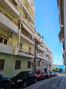 Eine Reihe von Autos, die an der Seite eines Gebäudes geparkt sind. in der Unterkunft Chalkida blue wave in Chalkida