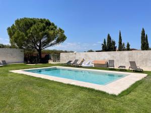 a swimming pool in a yard with chairs and a tree at Can Padrosa Mini loft 4 in Riumors