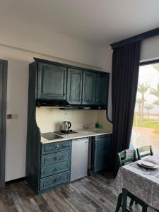 a kitchen with green cabinets and a table and a table and chairs at Casa Clara Pool Strand Meerblick in Khlorakas