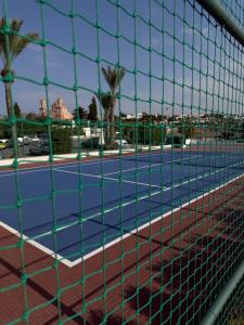 a tennis court with palm trees and a net at Casa Clara Pool Strand Meerblick in Khlorakas