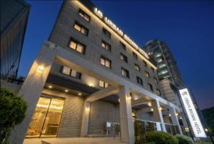 ein hohes Gebäude mit Lichtern auf dem Dach in der Unterkunft Urban Brown Hotel in Gunsan