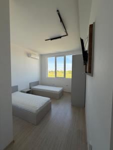 a white room with two beds and a flat screen tv at Хостел Дебелт in Debelt