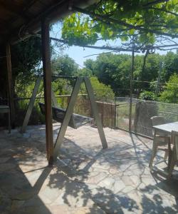 a swing set on a patio with a table at Riverbird House in Kymi
