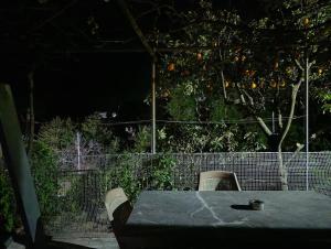a table and chairs in a backyard with an orange tree at Riverbird House in Kymi +4 photos