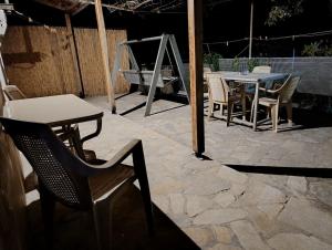 a patio with a table and chairs and a table and a table and chairs at Riverbird House in Kymi