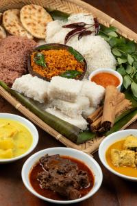 a tray of different types of food on a table at Wave Hostels Arugam Bay - With Swimming Pool in Arugam Bay