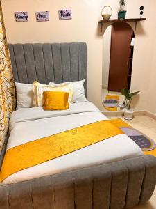 a large bed with a gray headboard in a room at Victory homes in Eldoret