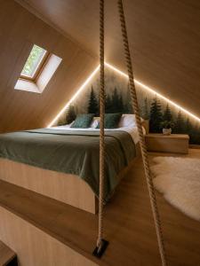 a suspended bed in a room with trees at The Landscape Barn Homes in Râşnov