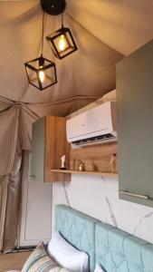 a living room with a couch and a tv and lights at Sutjeska Glamping Domes in Tjentište
