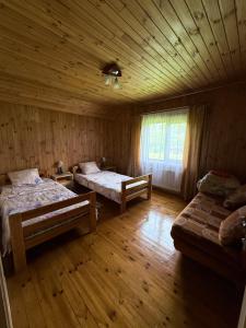 a bedroom with two beds and a wooden ceiling at Pakrasti in Svente