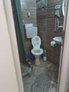 a small bathroom with a toilet and a sink at Casa OZZY&PATTY in 2 Mai